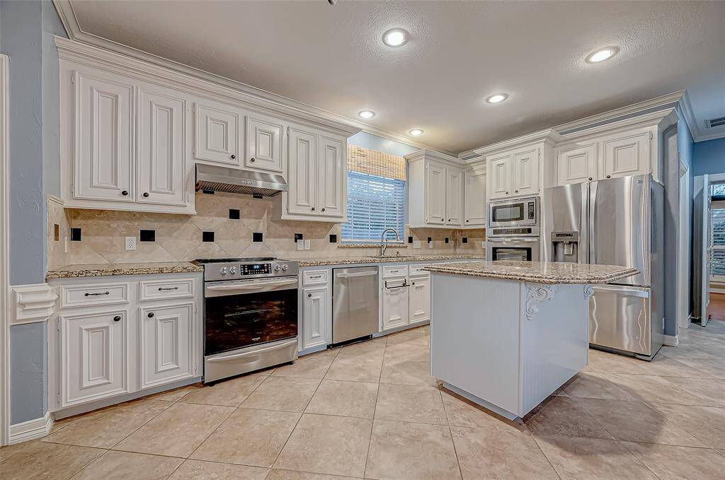 Updated kitchen with island, stainless steel appliance. Refrigerator included