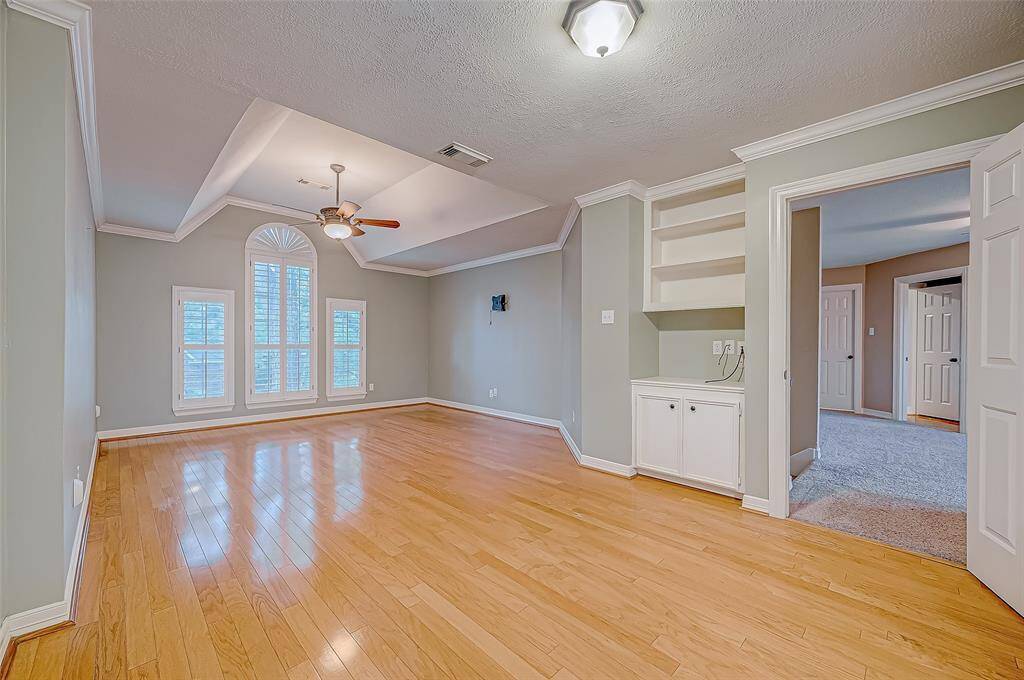 The Primary Bedroom offers a light and bright atmosphere with plantation shutters, built in shelving and storage as well as room for a sitting area.
