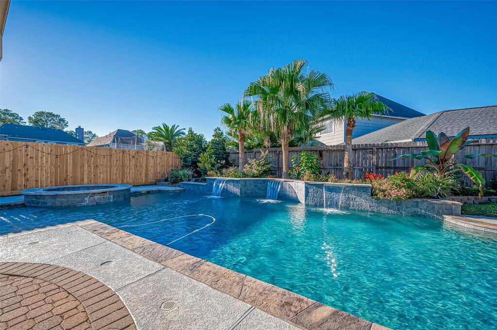 Serene oasis salt water pool and spa with waterfall features.