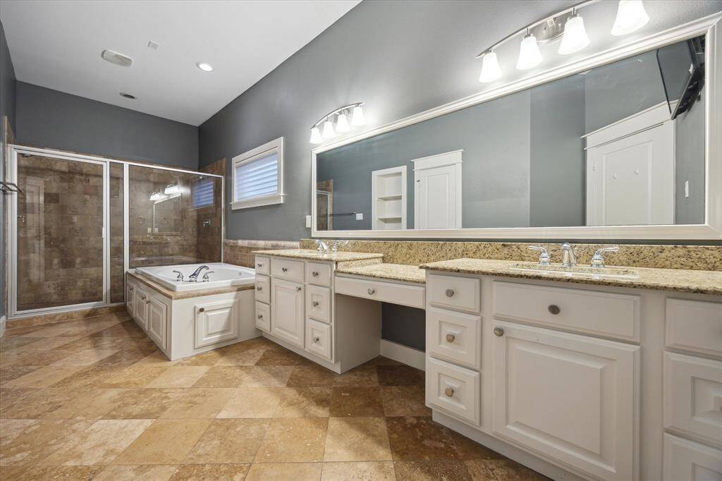 Amazing primary bathroom with double vanity - one w/knee-space. Primary bathroom has a separate tub and shower w/ a huge jetted tub!