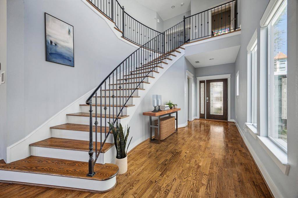 Gorgeous entry w/a stunning wrought-iron staircase w/ gorgeous wood floors throughout.