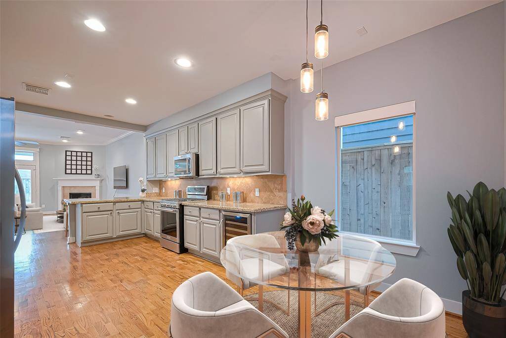 Eat-in breakfast area with views of beautiful cabinetry, wine fridge and back splash with a view out to the pool!