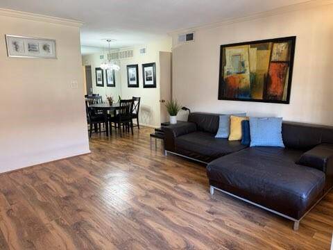 A spacious living and dining area with Laminate wood flooring.