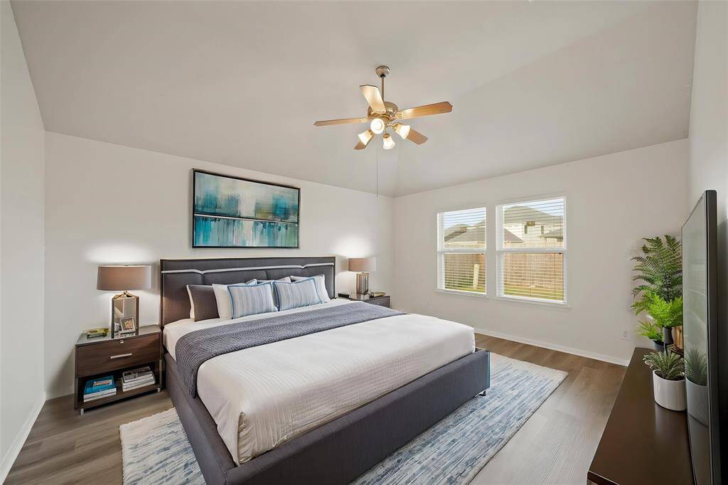 Virtually Staged: Come home and unwind in this AMAZING master suite! Featuring wood floor, a ceiling fan, and large windows with privacy blinds that provide plenty of light throughout the day.