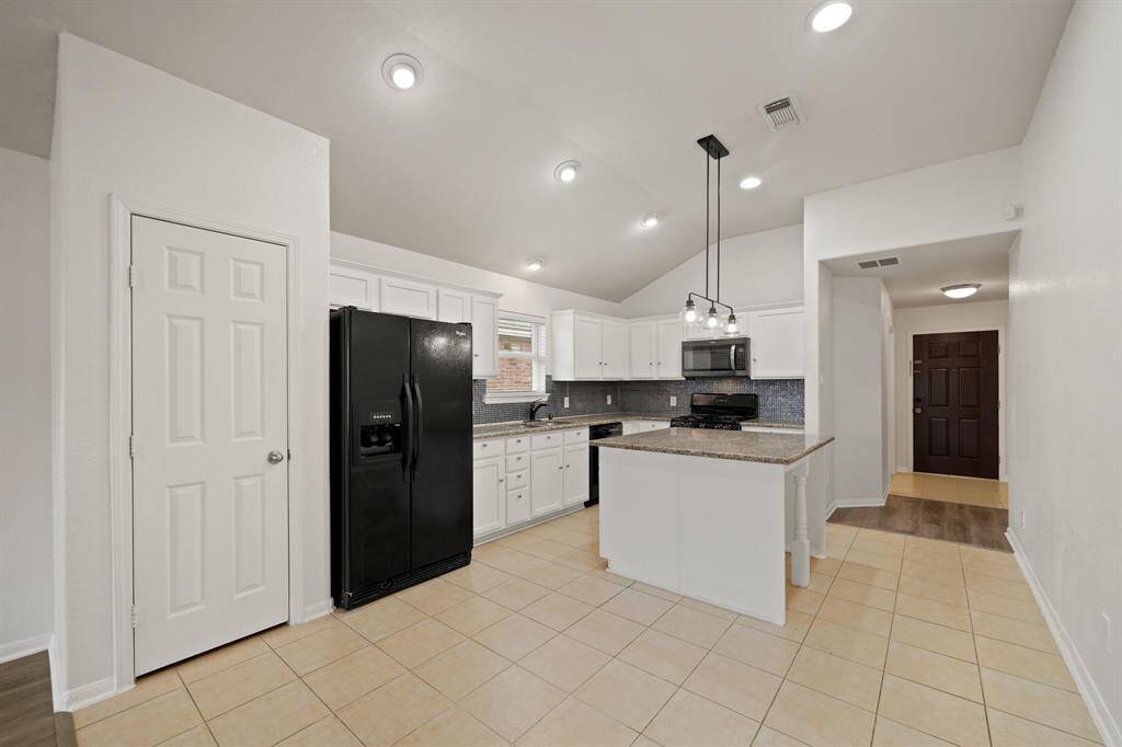 This beautiful kitchen is by far any home chef's dream! The kitchen has plenty of space to cook the perfect meal for your loved ones! Featuring gorgeous light cabinets, granite countertops, recessed and pendant lighting, oversized island, pantry, and gorgeous tile flooring!