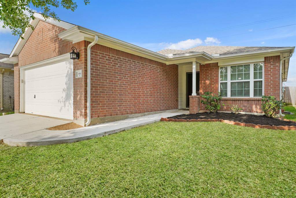 This beautiful home showcases a well maintained lawn and beautiful landscaping on a quiet street.