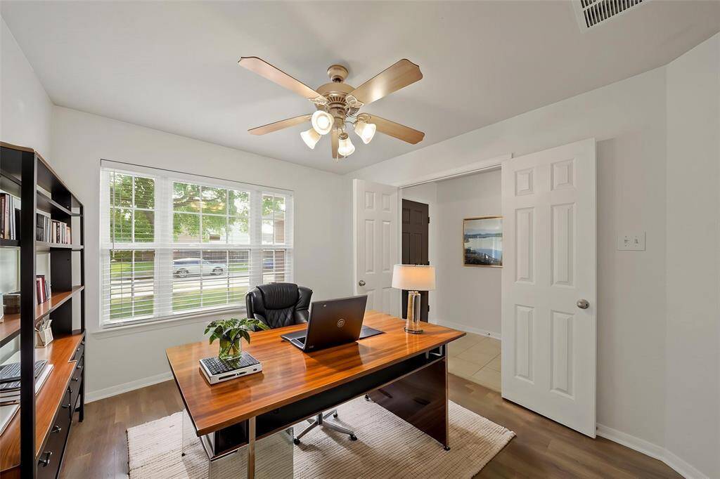 Virtually Staged: Quietly tucked away in the front of the home is the grand home office featuring neutral colors, wood floors, a ceiling fan, and a large window providing beautiful views from the front of the home and natural light!