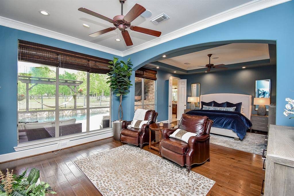The primary suite is located downstairs and has a seating area with fireplace. Windows provide wonderful views to the yard.