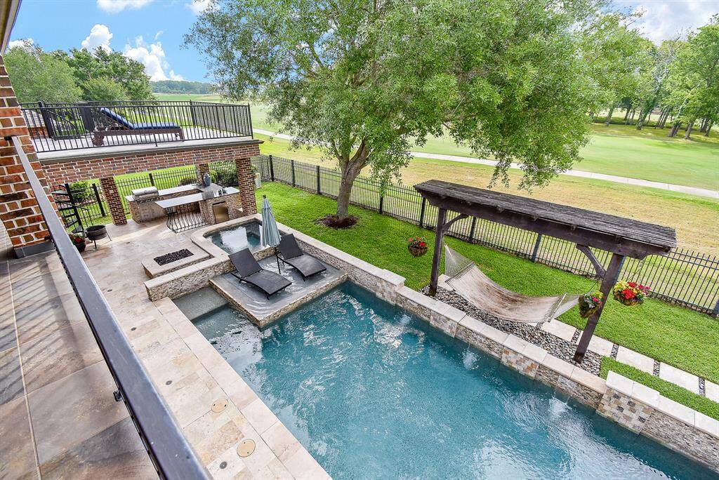 Pool surrounded by travertine tile with cascading waterfalls, The sun shelf is also perfect for small children or furry friends to cool off. The Spa and firepit arae a perfect compliment to this recreational pool. Covered and open balconies provides stunning views of the lush golfcourse as well as those special sunrises.