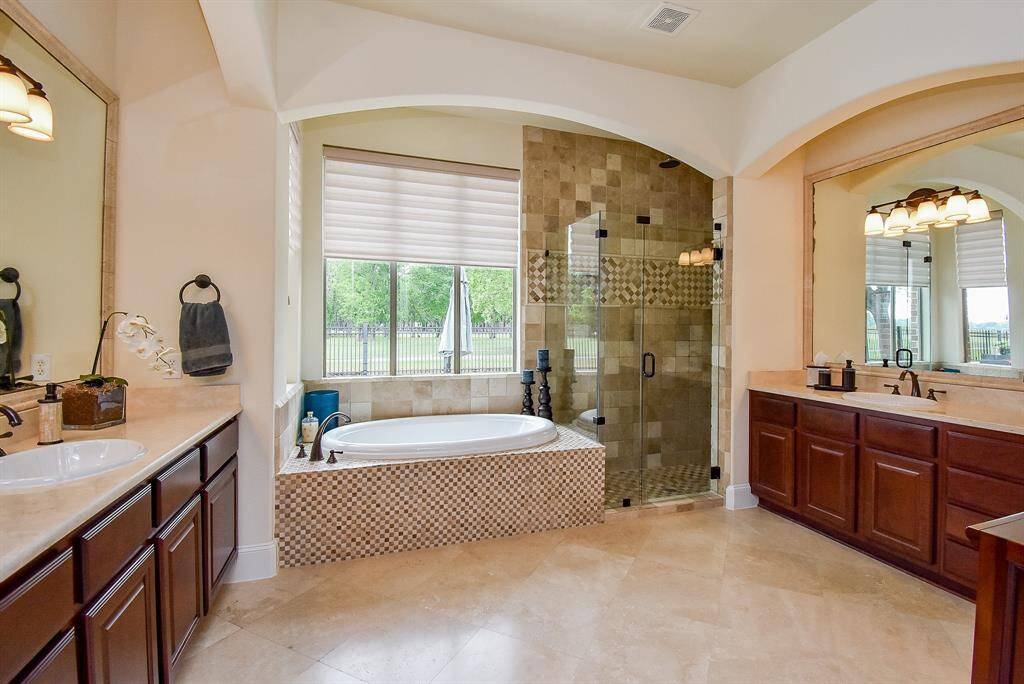 Master bath has two spacious vanities, a soaking tub and a large shower with frameless glass.