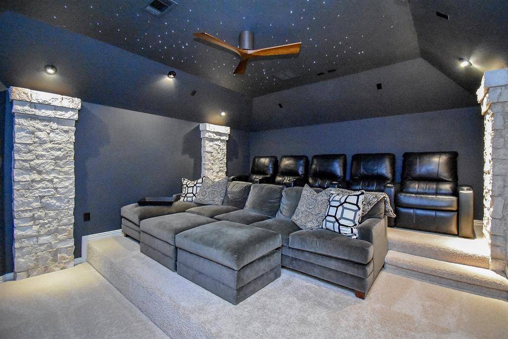 Media room with star ceiling and tiered seating options. Stone columns give theater vibes.
