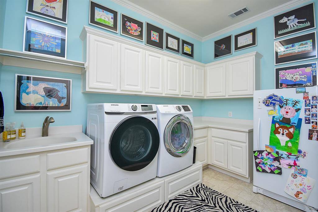 Large utility room with sink, and plenty of storage. Room for a fridge or freezer.