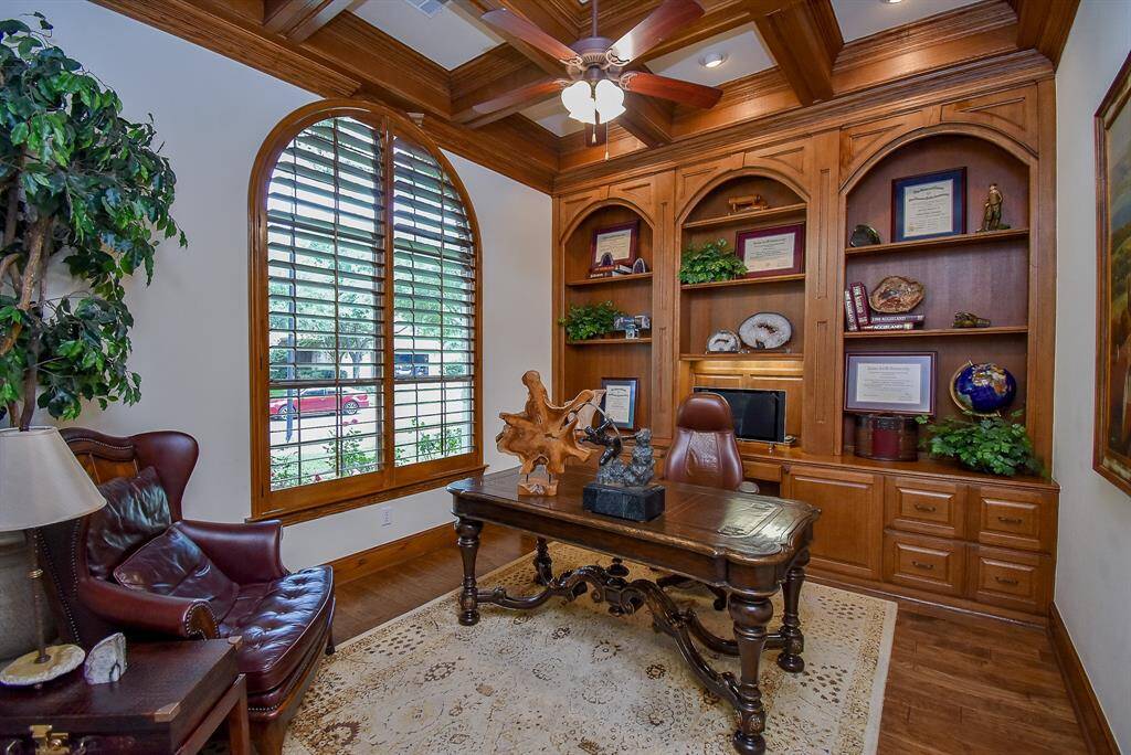 The study was thoughtfully enhanced with built in shelving storage. Plenty of room for a chair to sit and chat. Beamed ceiling and plantation shutters elevate the room.