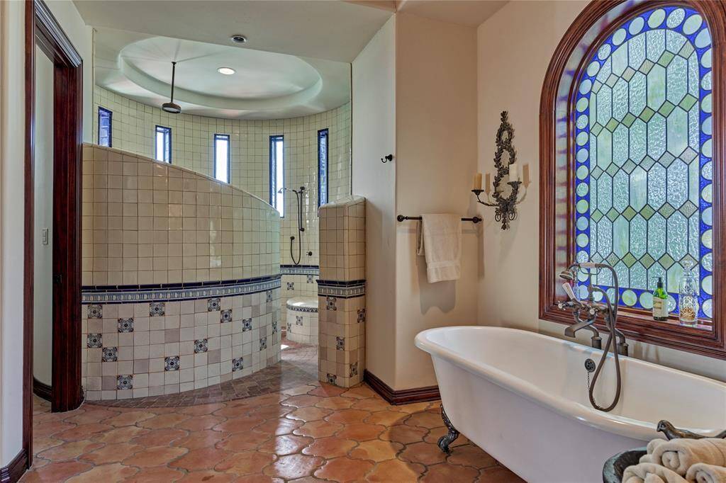 Leaded glass is the ideal backdrop to a centrally located soaker tub in this luxurious spa like bath.