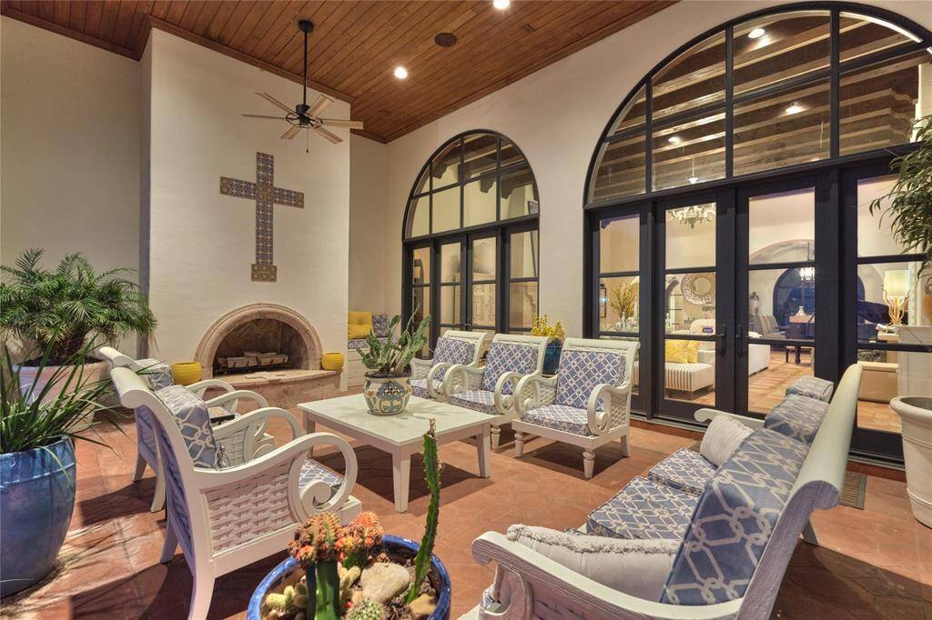 One of two verandas showcases a finished wood ceiling, fireplace, and outstanding views of Lake Conroe.