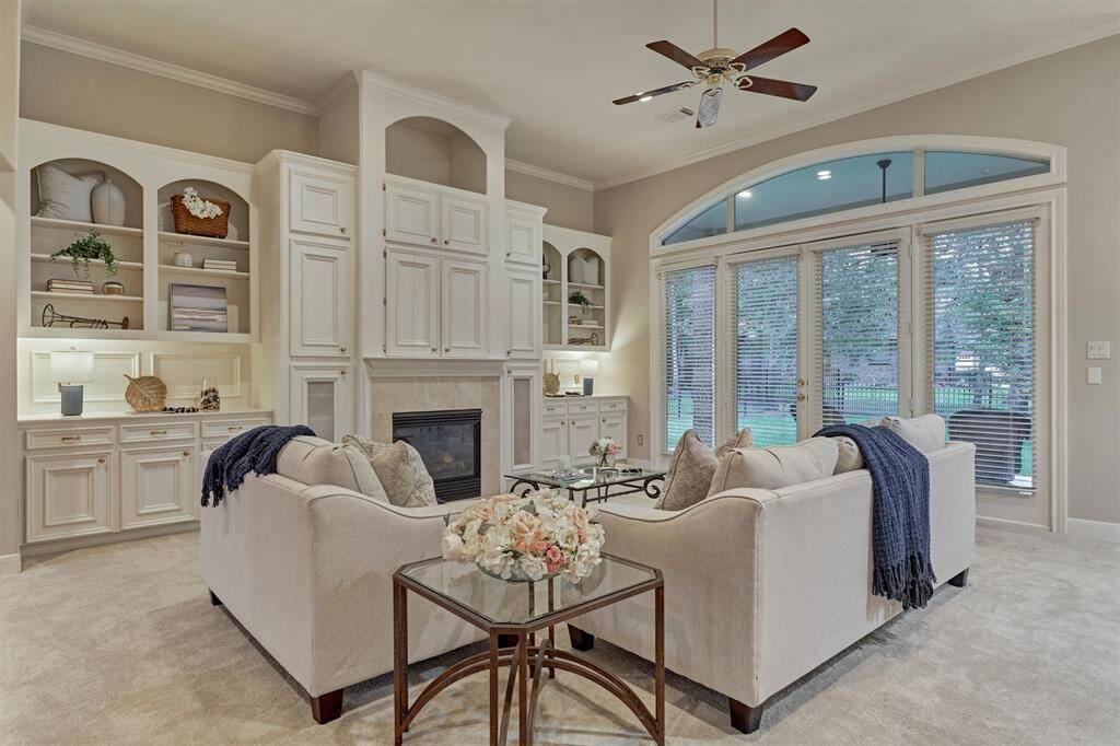 The light and bright living room has a wall of windows, high ceilings and tons of storage.