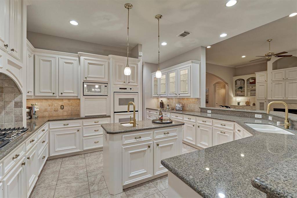This lovely kitchen is has a 5-burner gas cooktop, double ovens, stylish fixtures, stainless steel appliances and tons of storage.