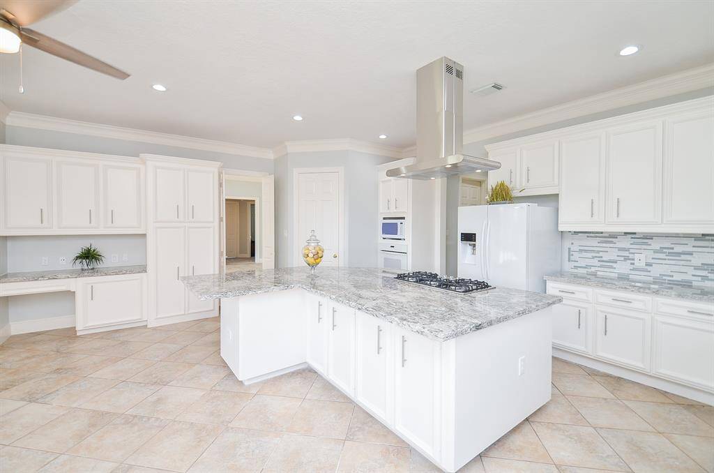 The Kitchen has Granite Counters, Ample Storage, a Large Walk-in Pantry and Desk Area.