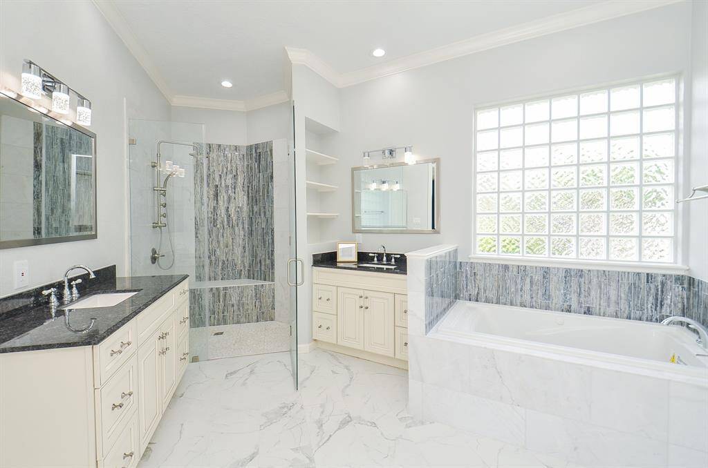 Indulge in Luxury with this Stunning En-Suite Bathroom, Featuring Dual Sinks, and a Relaxing Whirlpool Tub.