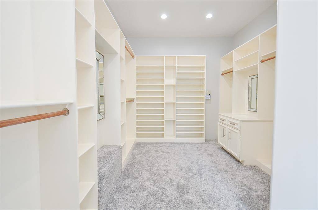 Discover a Walk-In Closet Oasis with an Island, Perfect for Organizing Your Wardrobe and Showcasing Your Style. Every Fashion Lover's Dream Come True!