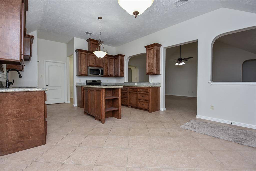 Deep honey colored cabinetry lines walls and floor space with storage and warm vibes.