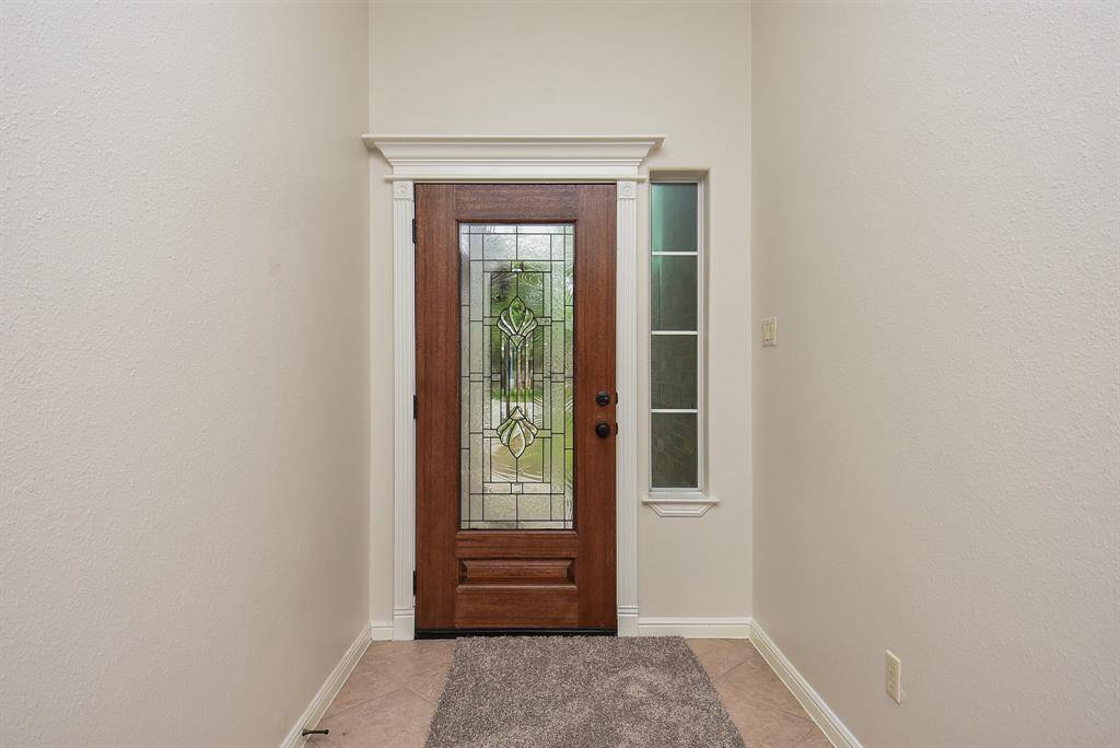 Cool, neutral tones fill the front entry, on the inside, on walls and floor.