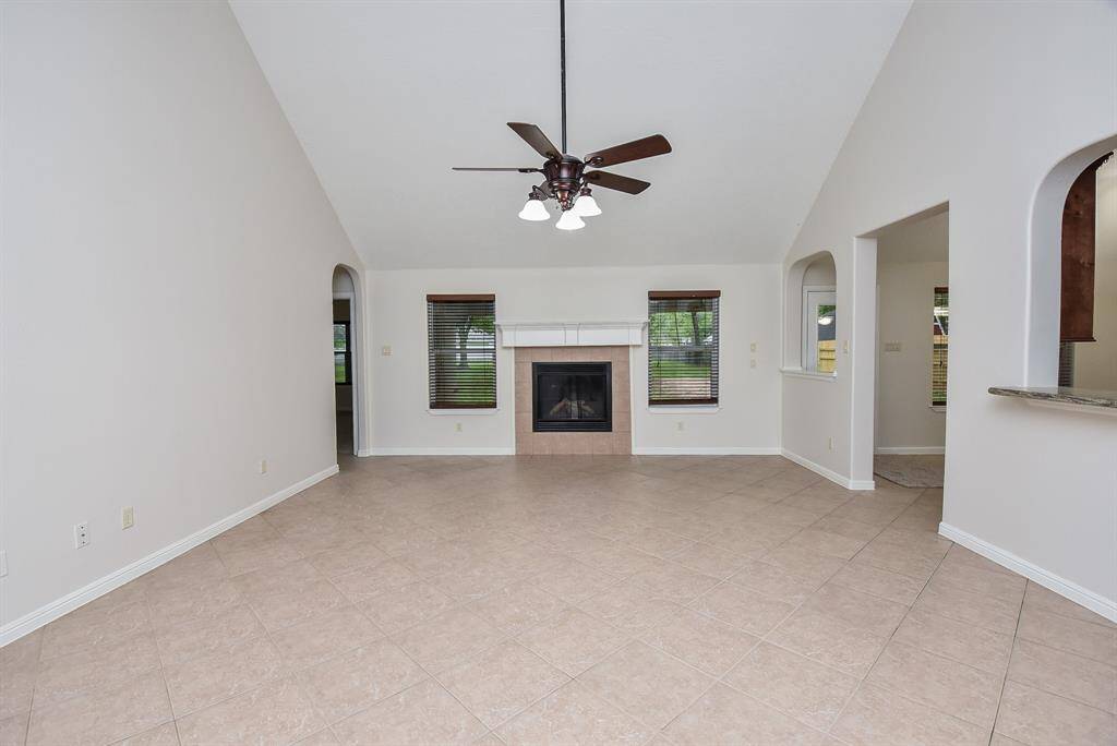 Symmetry in arched doorways on either side of the huge living/family space highlights great windows for natural light, the awesome fireplace (of course), and easily accessible paths through common areas.