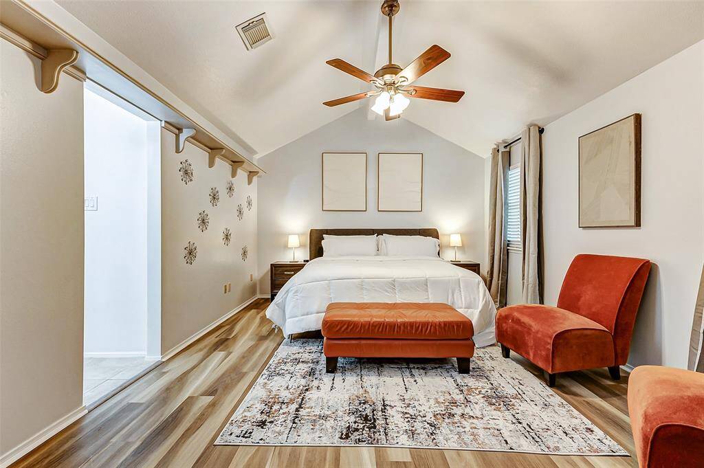 Serene and spacious, this primary bedroom features a vaulted ceiling, elegant  flooring, and abundant natural light, creating a perfect retreat.