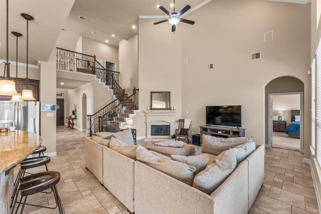 The heart of this inviting Family Room is the corner cast stone fireplace with a convenient gas starter and gas logs, offering both warmth and style. Designed for both function and comfort, this room also features Versailles tile flooring, recessed lighting, crown molding, and lighted ceiling fan. Click the movie reel icon to view a virtual walk-through tour of this amazing open floor plan!