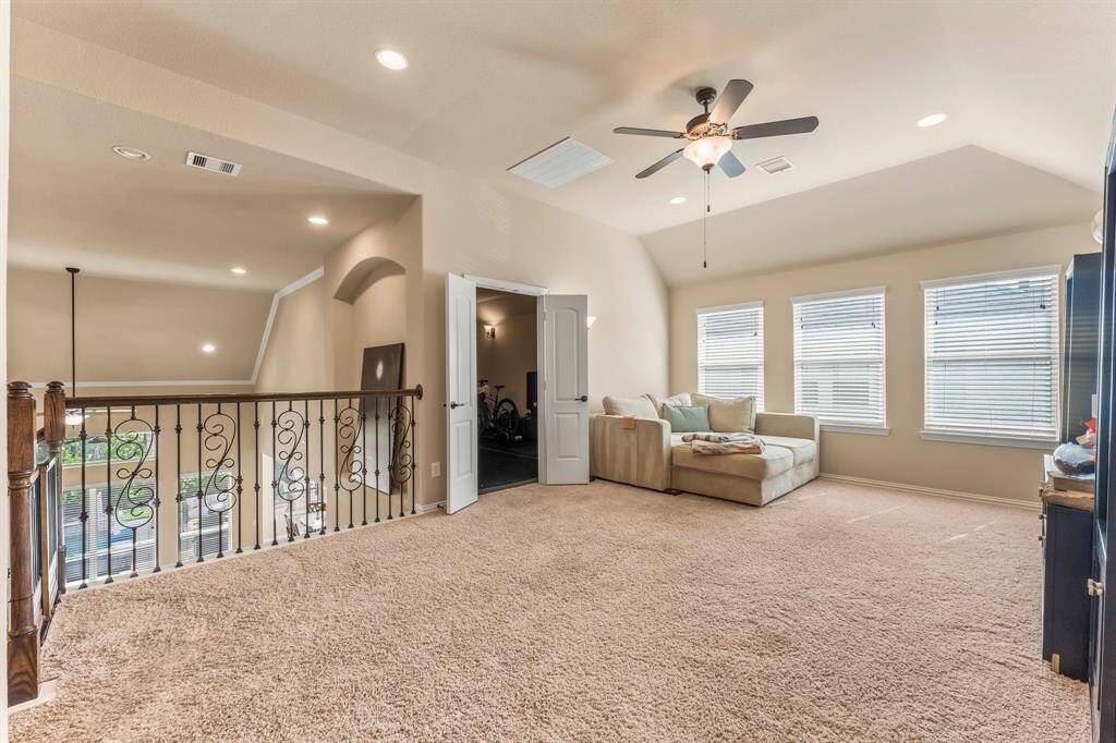 Step into the ultimate oversized game room—designed for fun and relaxation. Enjoy plush carpeting, a stylish sloped ceiling, recessed lighting, and abundant natural light from three large windows. A lighted ceiling fan adds comfort, while direct access to the media room expands your entertaining possibilities.
