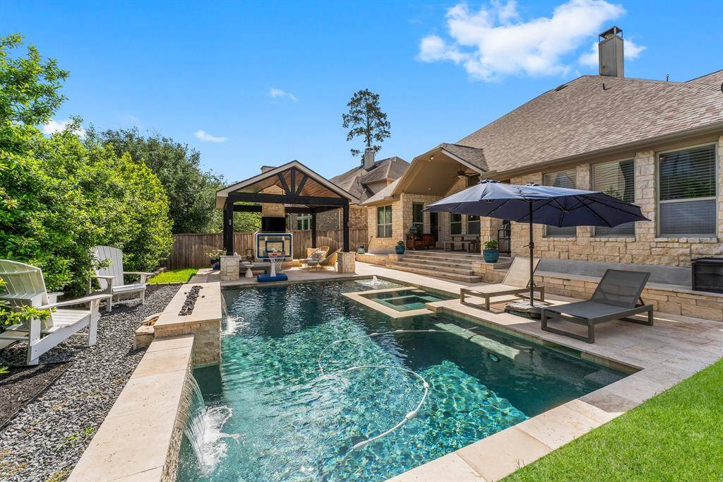 Before stepping inside, take a peek at this stunning backyard! Enjoy a covered porch with elegant travertine flooring, a gorgeous saltwater pool and spa featuring three waterfalls, a fire feature, and a baja sunning shelf with relaxing bubblers. Relax under the gazebo with room for your furniture around this gorgeous stone fireplace!