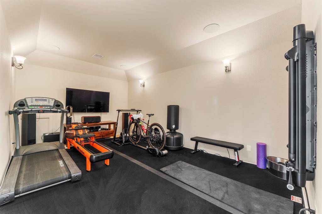 Located just off the game room, this spacious bonus room is currently set up as a home gym, but its potential is limitless. Whether you envision a second home office, media room, creative studio, or craft room, this flexible space can easily adapt to your needs. Surround sound speaker wiring, dimmable sconce lighting, lush carpeting, sloped ceiling, and no exterior lighting create the ultimate viewing atmosphere if you wish to use it as a Media room! TV is included- please exclude stereo equipment.