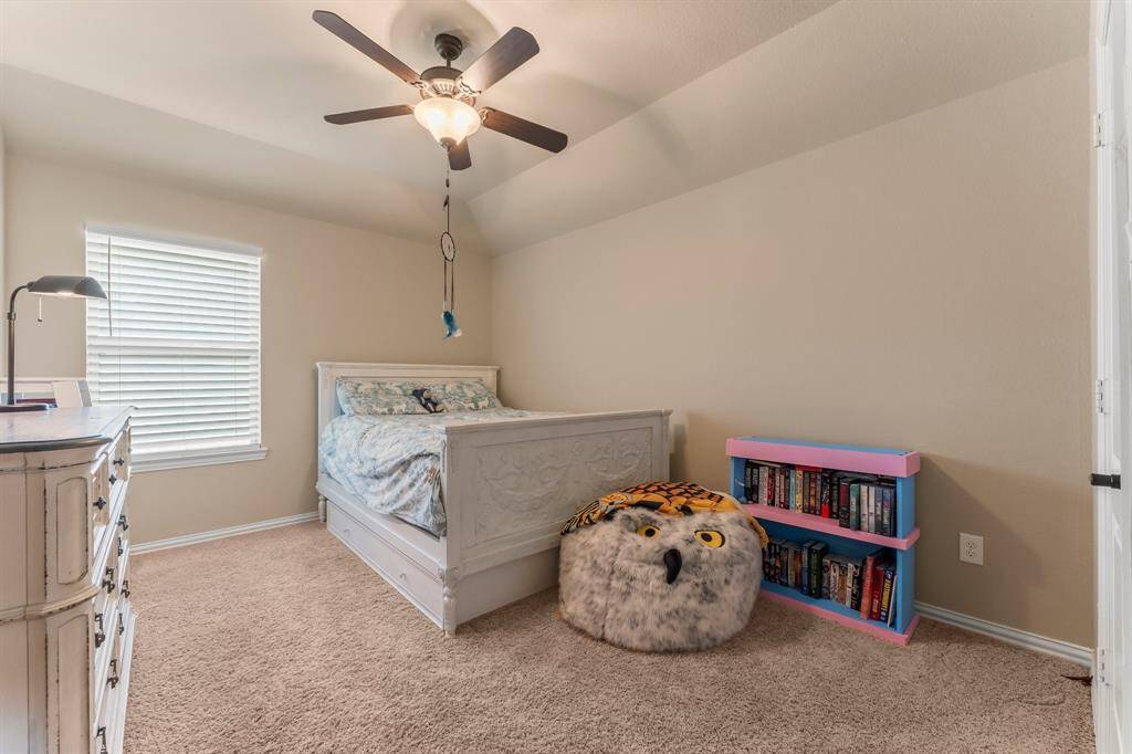 Another secondary bedroom offers lush carpeting, sloped ceiling, large walk-in closet, sunny window with blinds, and lighted ceiling fan. In the closet is also direct access to a floored attic storage area.  This bedroom has hallway access to a full bath shared with any visiting Game/Media guests.