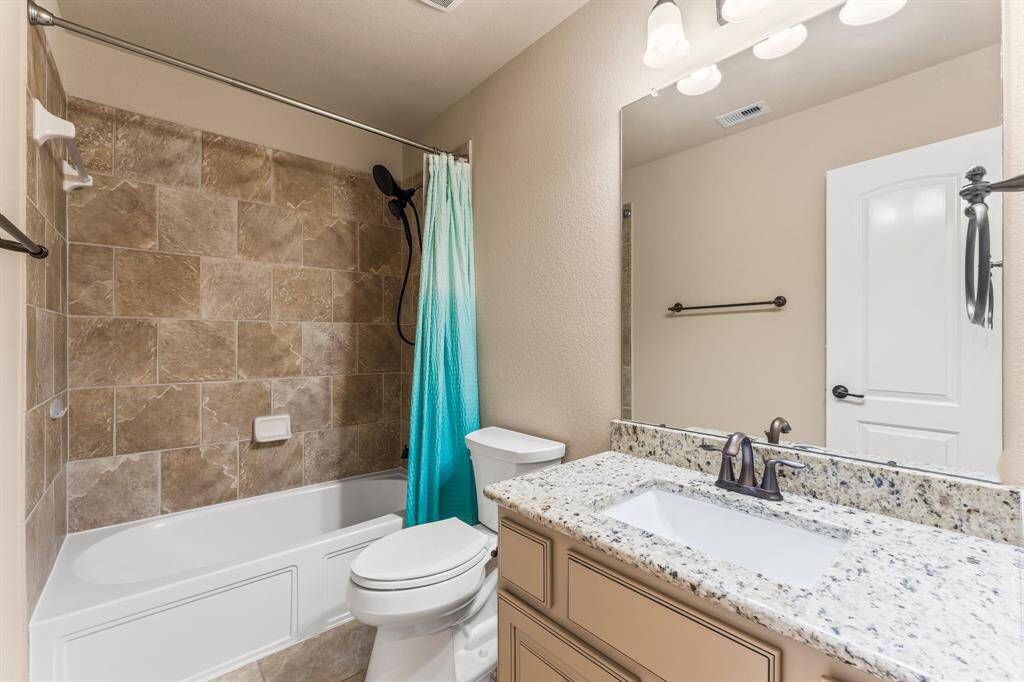 This full bath services the fifth secondary bedrooms and any game room or media room visitors. It features Versailles tile flooring, single rectangular undermount sink with granite countertop, hall linen closet, toilet, and tiled shower/tub combo.