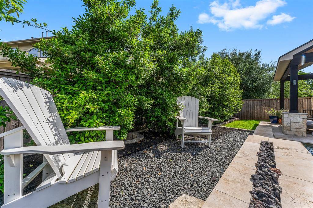 Cozy up by the pool's fire feature during cooler winter months with two perfectly placed chairs—ideal for sipping your favorite drink, sharing conversation, or simply enjoying the warmth and glow of the fire.