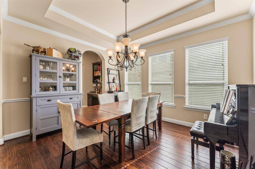 Gather your guests and celebrate in this stunning Formal Dining Room, designed for both grandeur and comfort. With plenty of space for a large dining table and full furniture suite, this room is perfect for any special occasion. It features wood flooring, three windows for natural light, tray ceiling with crown molding, elegant chair rail, and a designer chandelier. There is also a butler’s pantry area leading to the kitchen featuring a chef’s desk and shelving for additional storage.