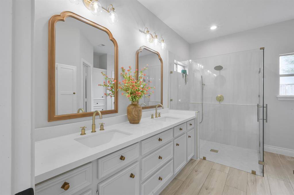 Linen cabinet provides ample storage for towels. You also see a peek into one of two walk-in closets in the primary bedroom. Be sure to check out the built-in ironing board that tucks away nicely when not in use.