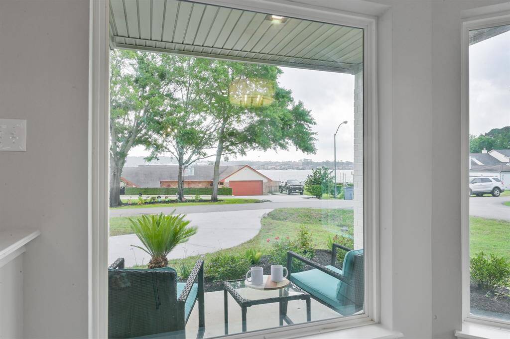 The beauty of the outdoors flows indoors through the oversized picture windows with views of the porch, landscaping, and lake beyond.
