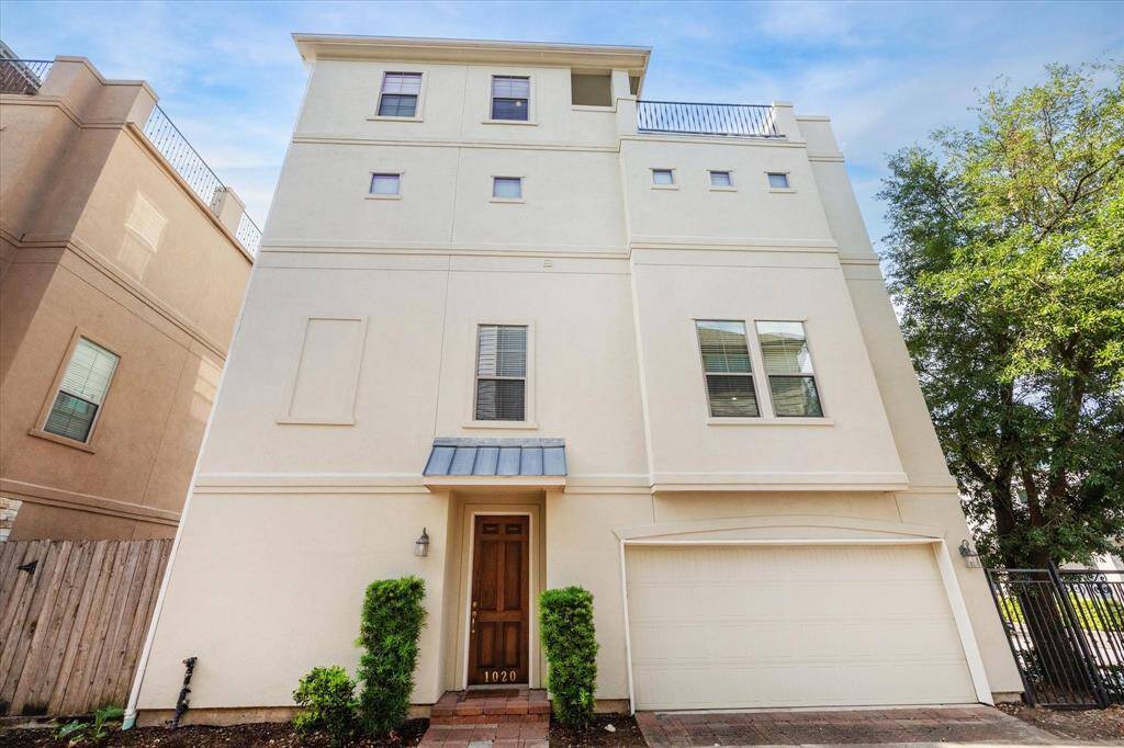 Impressive four-story stucco patio home freshly painted for a crisp, modern look. Elegant iron balcony railings add timeless charm and architectural detail, enhancing the home’s refined curb appeal. A perfect blend of classic style and updated finishes in the heart of the city.