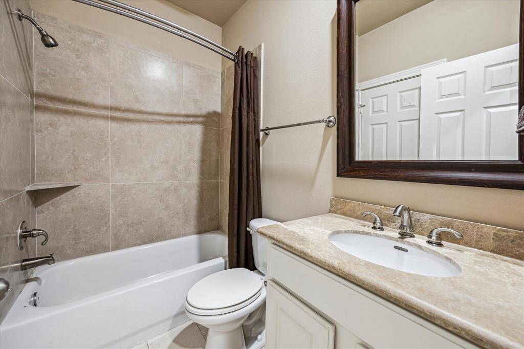 First-floor en-suite bathroom features a granite countertop, neutral colors, and a bath/shower combo—combining style and functionality.