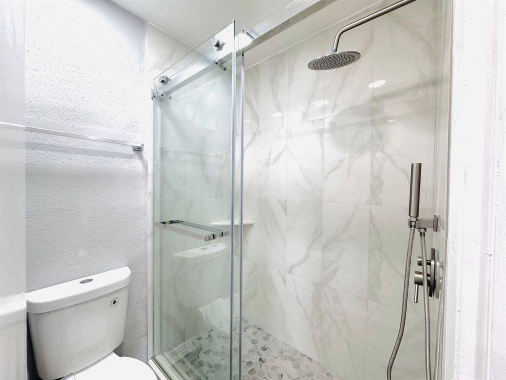 Indulge in luxury in this spacious bathroom. Featuring modern fixtures and a large walk-in shower, it provides the perfect combination of style and functionality.
