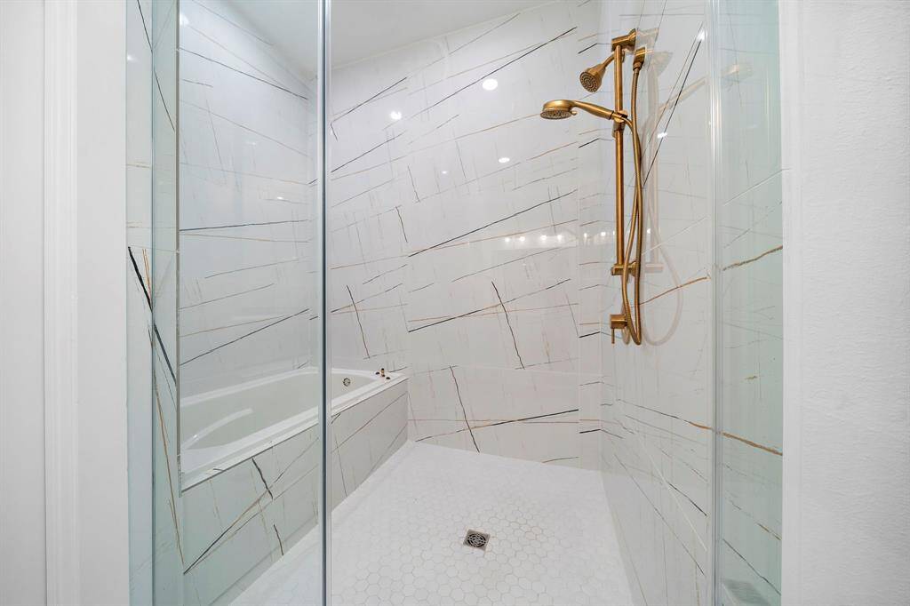 The large glass shower with striking modern tile, a soaking tub and rain showerhead.