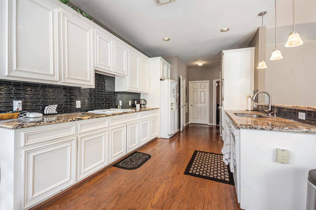 Kitchen with granite counters and tile backsplash.