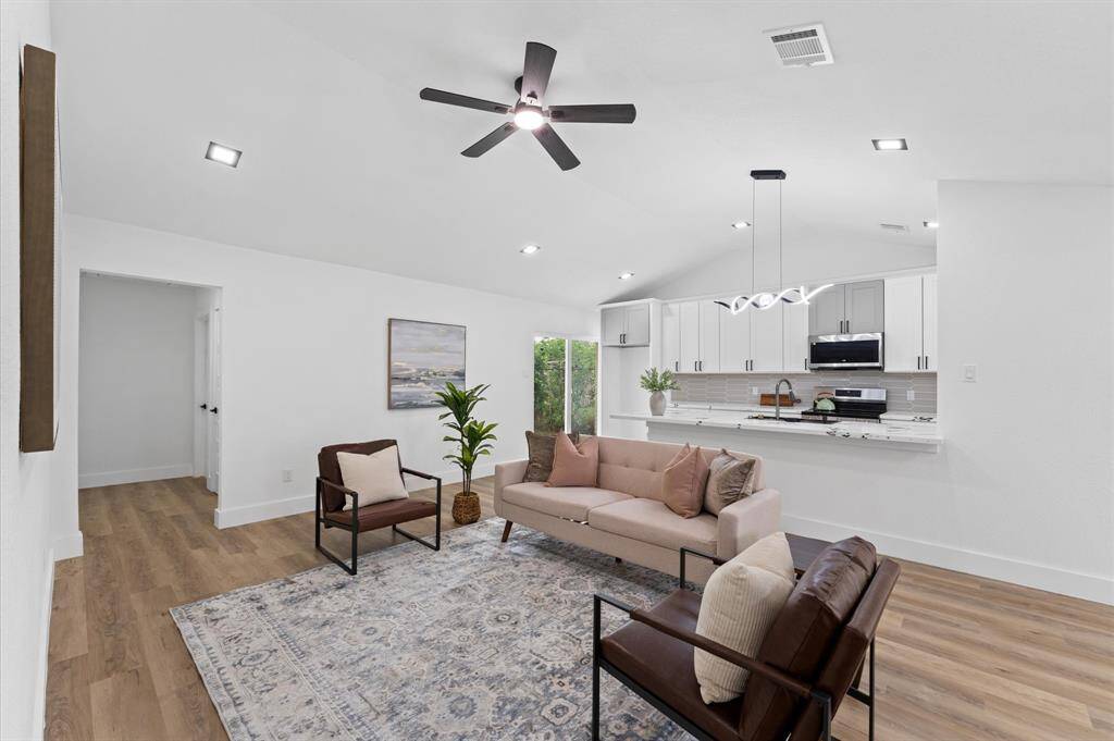 Spacious living area with fresh paint, new doors, new baseboards, new light fixtures and new flooring