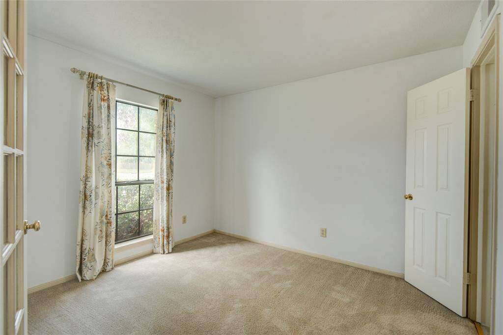 Bright and versatile first-floor bedroom with large windows—ideal as a guest room or home office.
