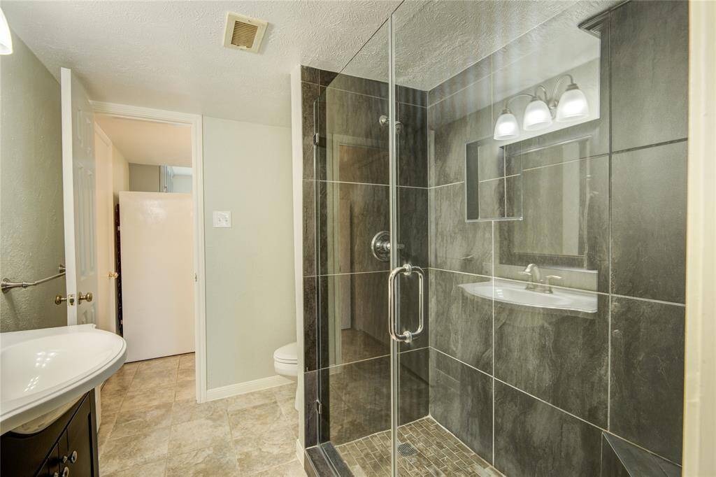 Stylish ensuite bath with an oversized walk-in shower and direct access to the kitchen.