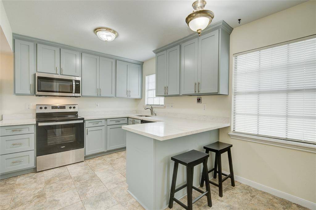 Convenient breakfast bar seamlessly connects kitchen and dining areas for effortless entertaining.
