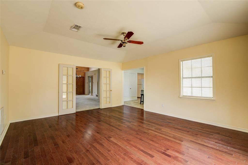 Spacious living area with elegant French doors opening to the formal dining room and easy access to the kitchen.