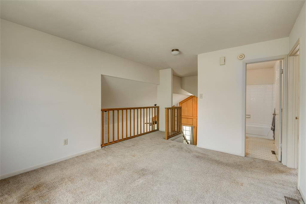 Versatile upstairs flex area overlooking the living room, featuring a full bath and spacious walk-in closet.