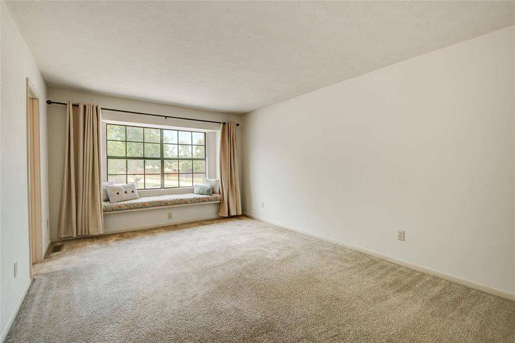 Spacious upstairs primary suite with a charming picture window and built-in bench seating overlooking the cul-de-sac.